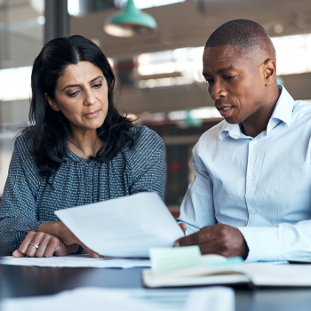 two people viewing paper in office