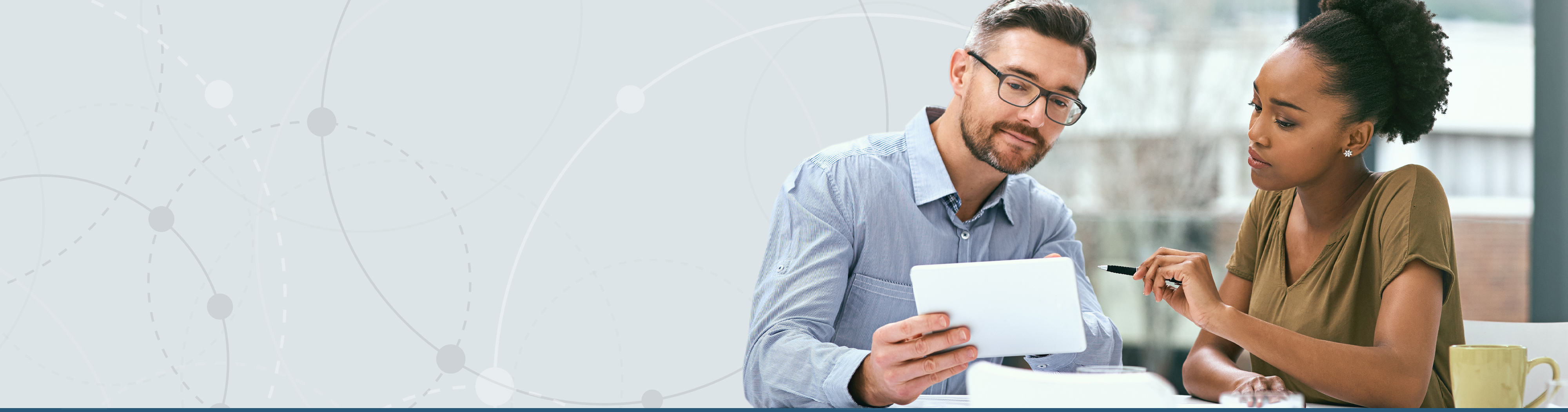 two people viewing paper together in office